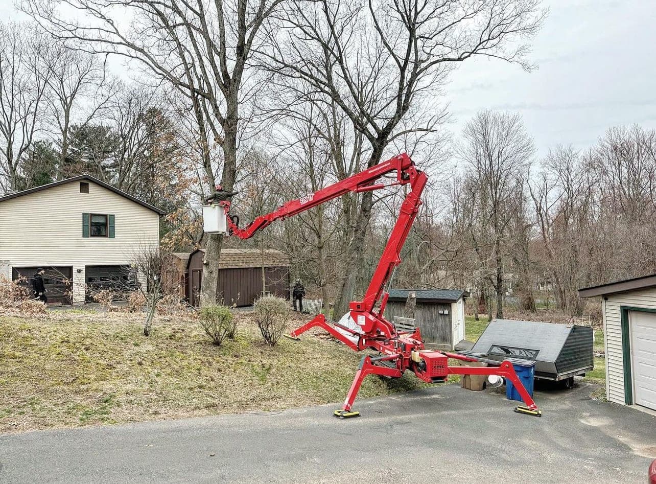 Spider lift working in a yard between two houses