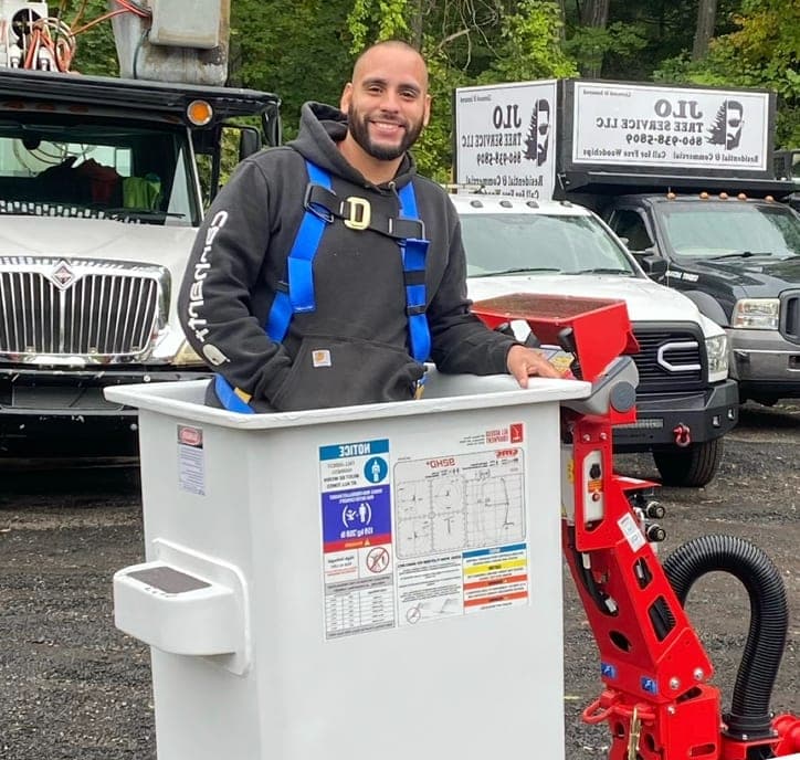 Smiling crew member in a harness standing in a lift bucket