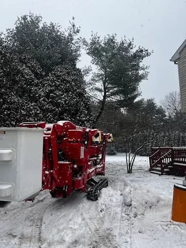Spider lift parked in the snow beside a house
