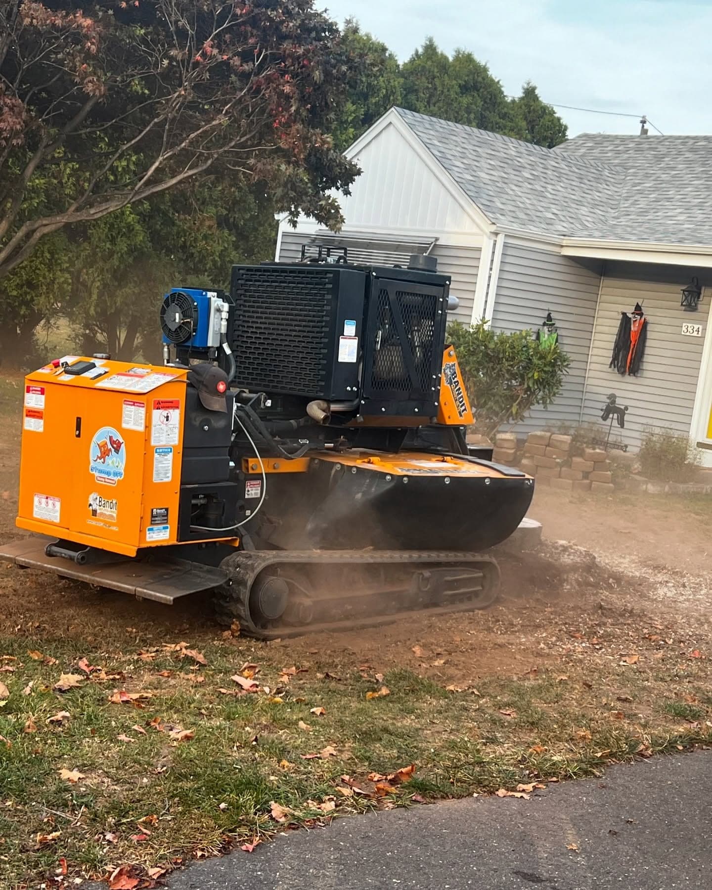 Tracked stump grinder working in a front yard