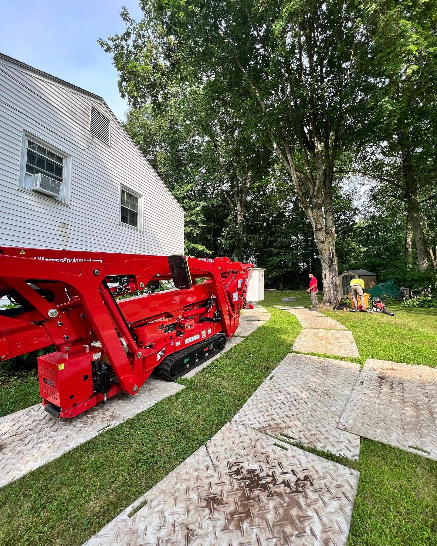 Folded spider lift on ground mats protecting a lawn