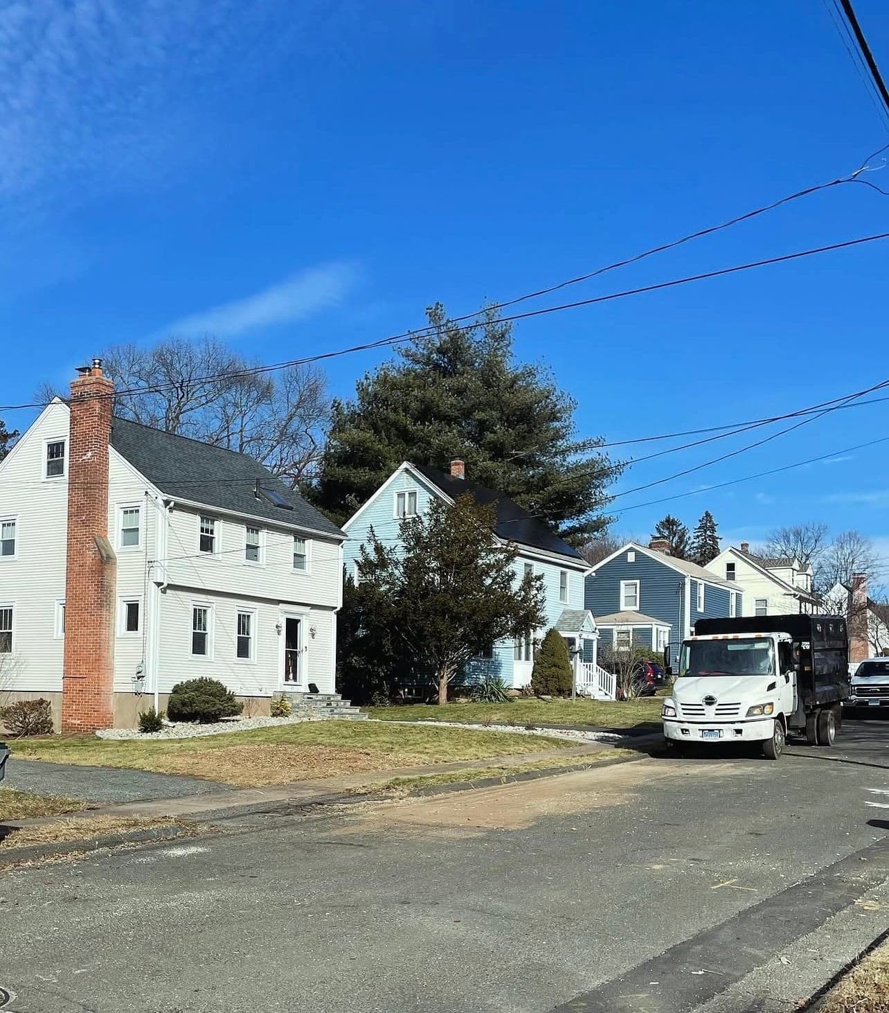 After: the same house with the tree gone and JLO's truck at the curb