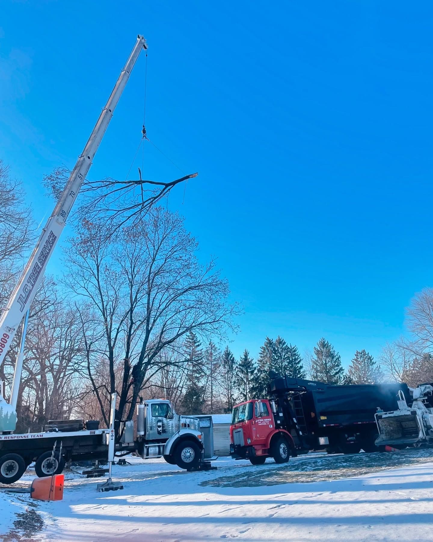 JLO Tree Service crane and trucks on a winter tree removal job in central Connecticut